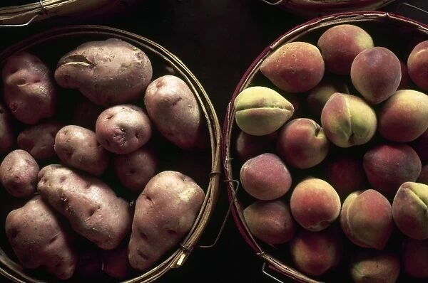 POTATOES AND PEACHES. A bushel of potatoes and a bushel of peaches at the French Market in New Orleans, Louisiana. Photographed c1974