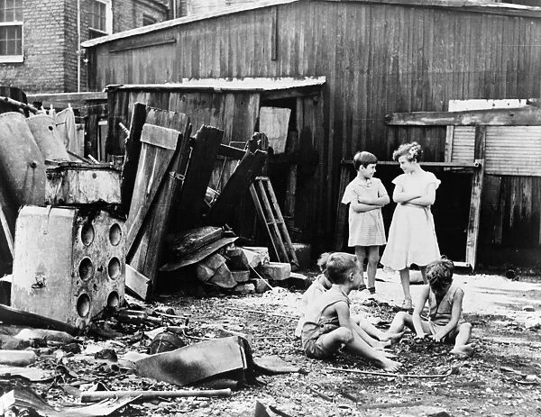 POVERTY: CHILDREN, 1935. Children playing in their backyard in the slum district of Washington, D