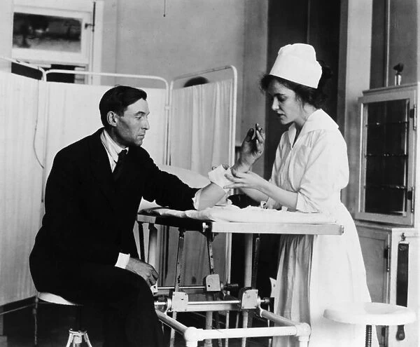 PUBLIC HEALTH SERVICE, c1920. A Public Health Service nurse treating a patient