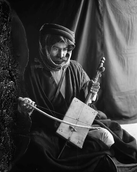 RABABEH PLAYER. An Arabic man playing a rababeh, a single string instrument, with a bow