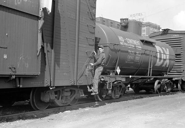 RAILROAD, 1940. A boy hopping a freight train in Dubuque, Iowa. Photograph by John Vachon