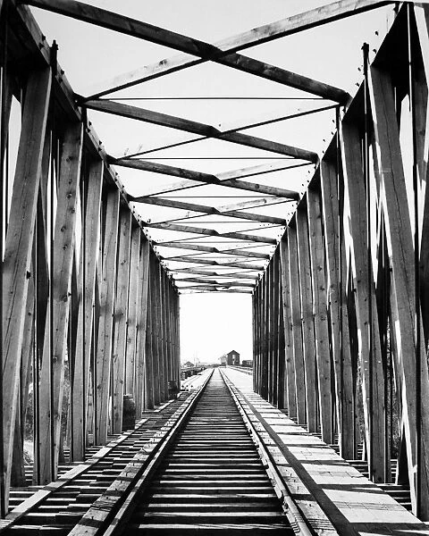 RAILROAD BRIDGE: RED RIVER. Looking west through the original Northern Pacific Railroad bridge across the Red River between Moorhead, Minnesota, and Fargo, North Dakota, completed in May 1872