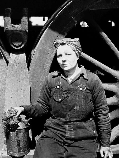 RAILROAD WORKER, 1943. A female worker cleaning one of the giant locomotives of the Chicago