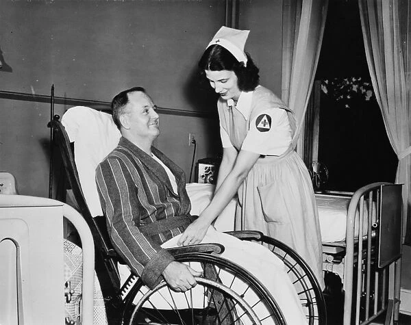RED CROSS, c1942. A Red Cross nurses aid with a patient in an American hospital