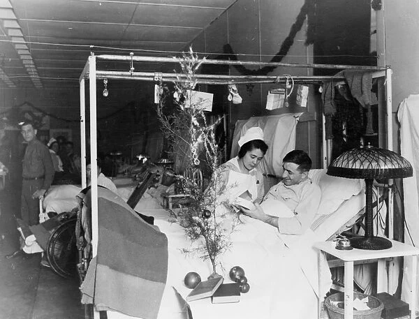 RED CROSS: CHRISTMAS. An American Red Cross nurse alongside a wounded soldier during the Christmas season. Photograph, c1915