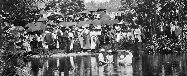 RIVER BAPTISM, c1900. A crowd observing a river baptism. Photograph, c1900