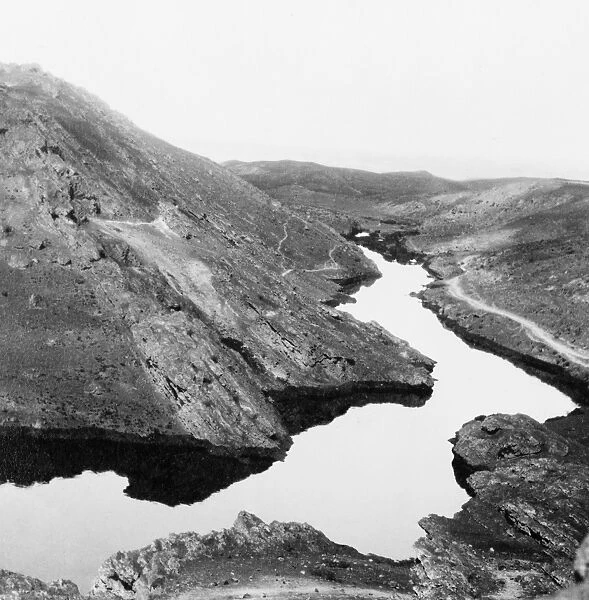 A river of crude oil flowing through the Kirkuk district of a Iraq, the result of an uncontrolled gusher in an oil field. Photograph, c1932