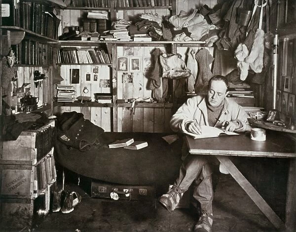 ROBERT FALCON SCOTT (1868-1912). English Antarctic explorer. Scott writing up his journal in his cabin in the Antarctic. Photographed by Herbert Ponting, 1911