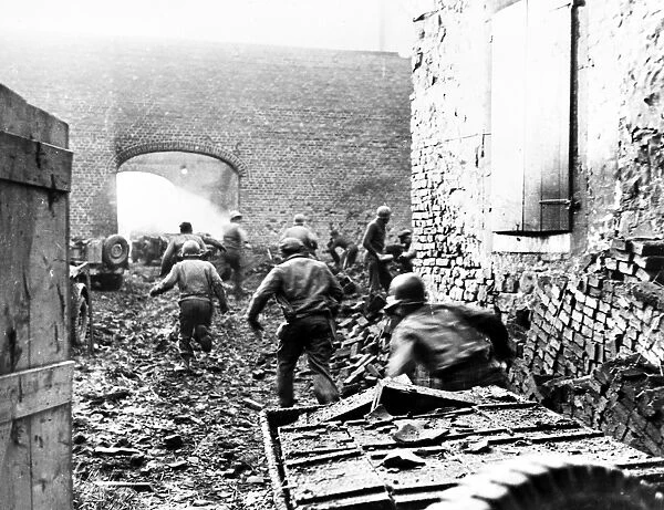 After a round of bombardment by artillery shells, members of the 87th Mortar Division, U. S. First Army, at Echtz, Germany, move out from behind shelter to fire back at entrenched German positions, 14 December 1944