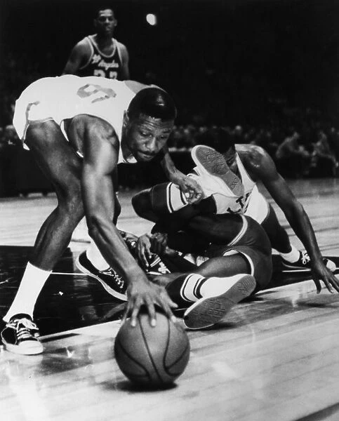 BILL RUSSELL (1934- ). American basketball player. Russell, playing for the Boston Celtics, reaching for a free ball rolling away from his teammate Sam Jones and Leroy Ellis of the L. A. Lakers during a game at Madison Square Garden in New York City, November 1963