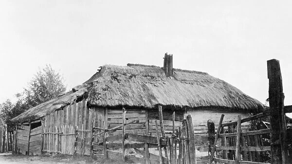 RUSSIA: LOG HOUSE, c1918. A peasants log house with thatched roof. Photograph, c1918