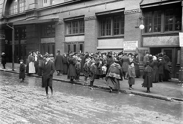 SALVATION ARMY, 1908. Crowd waiting at basket distribution window for Christmas dinner from the Salvation Army, New York City