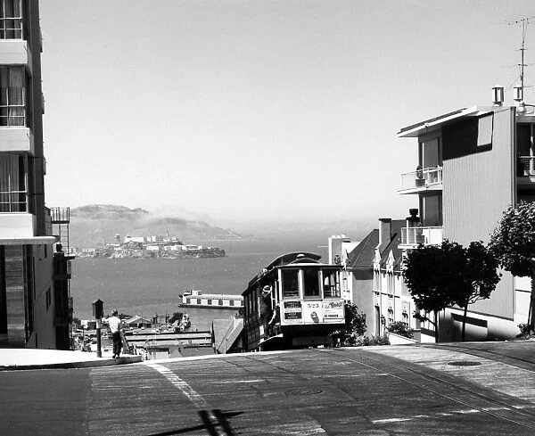 SAN FRANCISCO: CABLE CAR. A cable car mounts Hyde Street in San Francisco, California. Alcatraz Island can be seen in the background. Photographed c1950