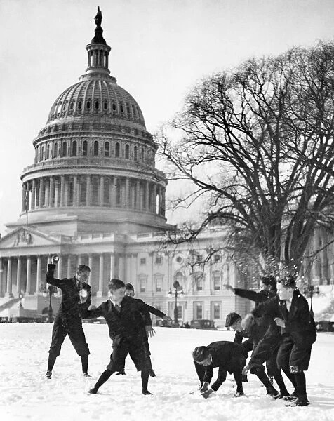 Senate page boys in a snowball fight in front of the U. S. Capitol in Washington, D. C. Photograph, early 20th century