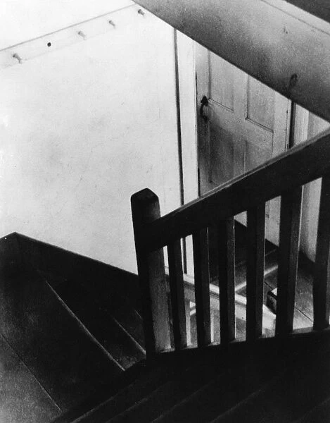 SHAKER STAIRCASE, 1930s. View from above of an interior stairwell in a building