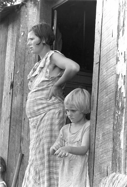 SHARECROPPERs WIFE, 1935. Pregnant mother and child of a sharecropped in their shack