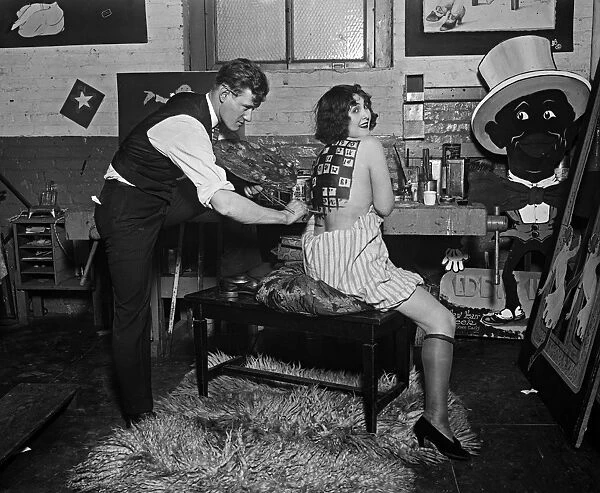 SHOWGIRL, 1925. A man painting a womans back backstage at a vaudeville theatre