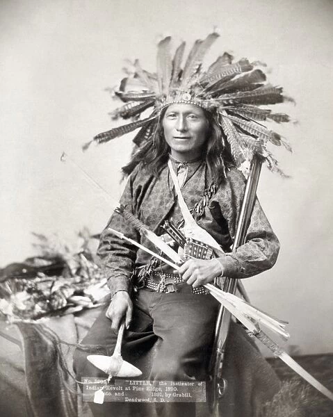 SIOUX LEADER, 1891. Little, the Oglala Sioux leader cited as an instigator of the revolt on the Pine Ridge Reservation in South Dakota in 1890, holding weapons and wearing a headdress made of turkey feathers. Photographed in 1891 by John C. H. Grabill
