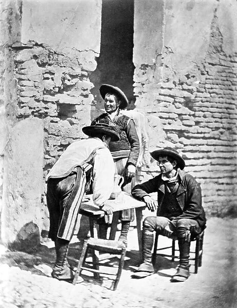 SPAIN: COWBOYS, c1875. Three Spanish cowboys around a outdoor table in Cordoba, Spain