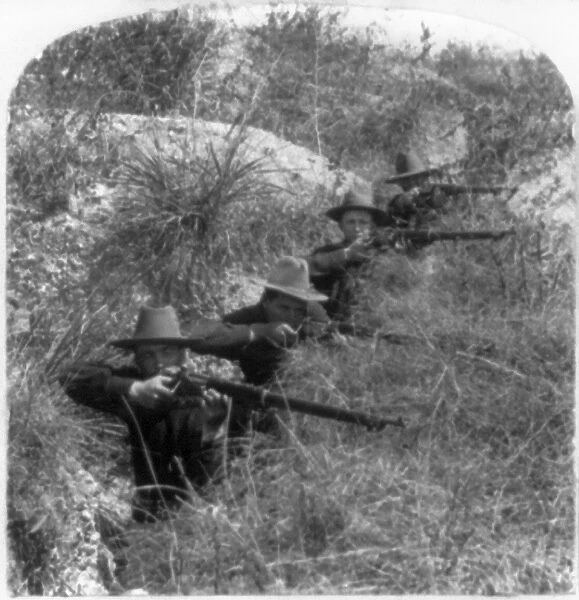 SPANISH-AMERICAN WAR, 1898. American soldiers shooting rifles in a trench in the
