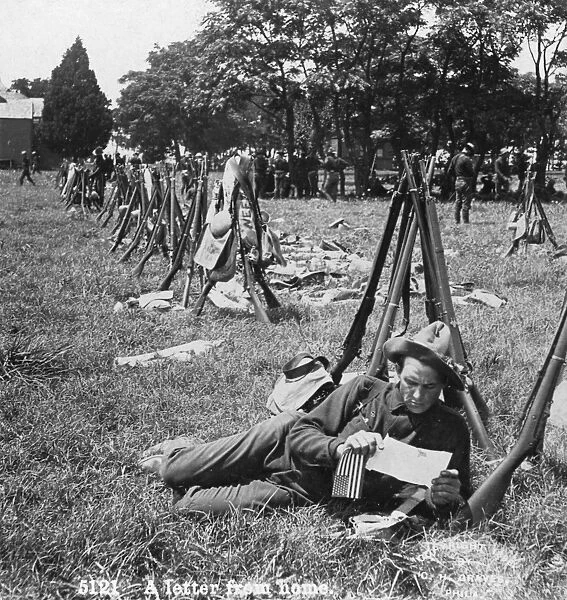 SPANISH-AMERICAN WAR, 1898. A soldier reading a letter at a camp during the Spanish-American War