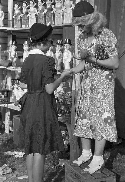 STATE FAIR, 1938. Young girl buying a doll from the concession manager at the Louisiana