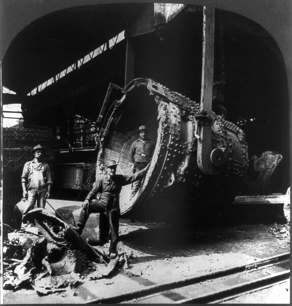 STEEL WORKERS, c1905. Steel workers cleaning and repairing a foundry ladle at the
