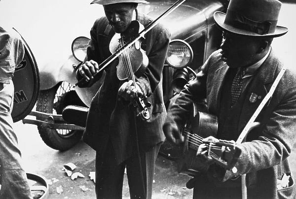 STREET MUSICIANS, 1935. African American street musicians in rural America. Photograph, 1935, by Ben Shahn