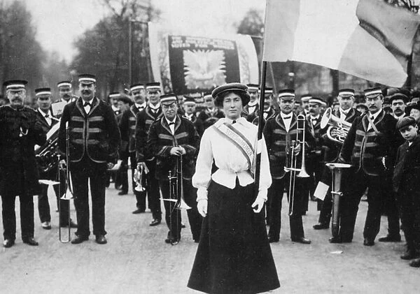SUFFRAGETTE PARADE, 1908. Daisy Dugdale bears the standard in a procession at London