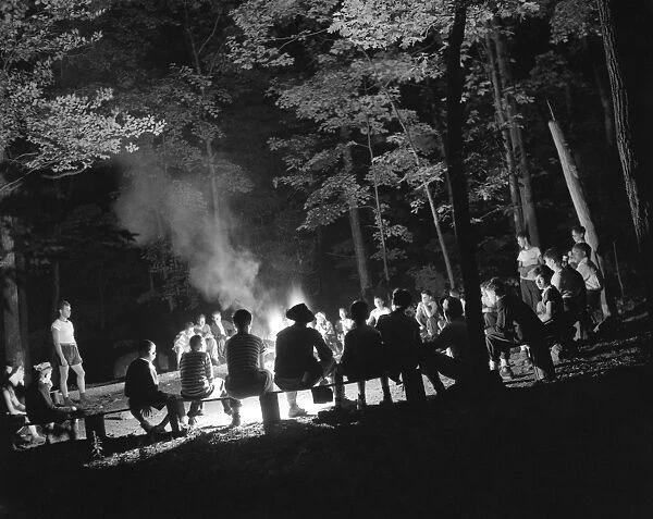 SUMMER CAMP, 1943. Campers sitting around a campfire at Camp Nathan Hale, an interracial