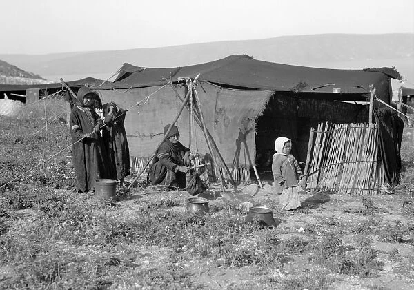SYRIA: BEDOUIN CAMP, c1936. A Bedouin woman churning butter with children outside