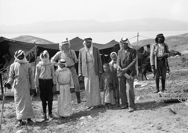 SYRIA: BEDOUINS, c1936. Group of Bedouins and a European man at a camp at Gamla