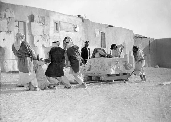SYRIA: PALMYRA, c1925. Workmen moving the massive capital of a column in Palmyra, Syria