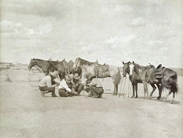 TEXAS: COWBOYS, c1907. Five cowboys gathered together as one of them draws a map