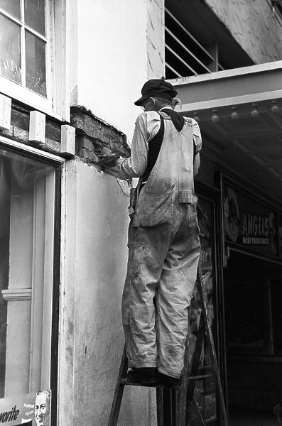 TEXAS: WORKMAN, 1939. A workman plastering a wall of a movie theater in Waco, Texas