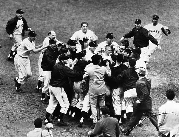 THOMSON HOME RUN, 1951. Bobby Thomson of the New York Giants being mobbed by teammates and fans after hitting his pennant-winning home run, the so-called Shot Heard round the World, against the Brooklyn Dodgers at the Polo Grounds in New York City, 3 October 1951. The hatless man third from left is Giants manager Leo Durocher