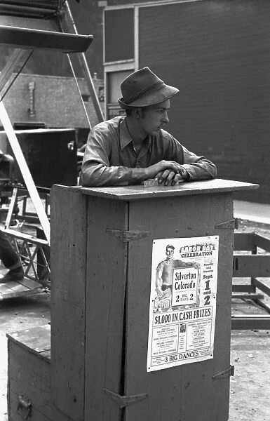 TICKET SELLER, 1940. Selling tickets for the ferris wheel ride at the Labor Day