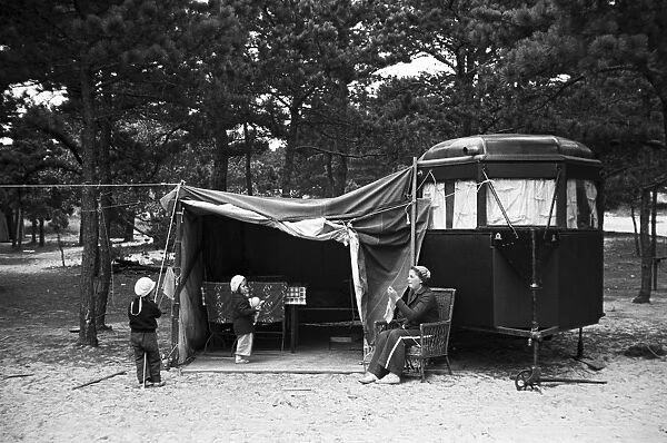 TRAILER CAMP, 1936. A mother and two children in front of their camper at a trailer