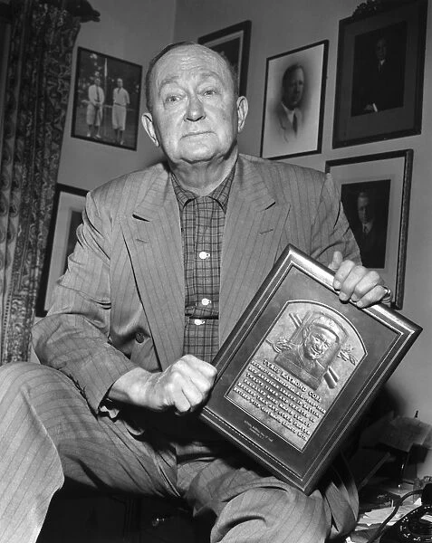 TY COBB (1886-1961). Tyrus Raymond Cobb. American baseball player. Cobb holding a replica of his Hall of Fame plaque, 1957