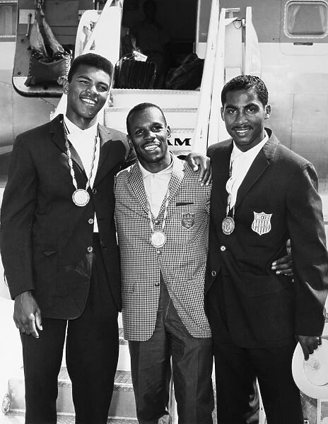 U. S. BOXING TEAM, 1960. The American Olympic boxing team and gold medal winners, left to right: Muhammad Ali (nÔÇÜ Cassius Clay), Eddie Crook and Willie McClure, photographed at Idlewild airport in New York on their return to America after the 1960 Summer Olympics in Rome, Italy