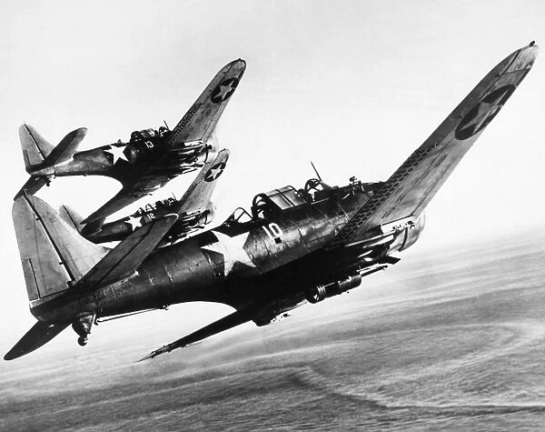 Three U. S. Navy Douglas SBD Dauntless dive bombers flying over the Pacific Ocean