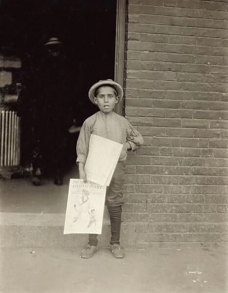 VERMONT: NEWSBOY, 1910. A young newsboy at a depot in Burlington, Vermont
