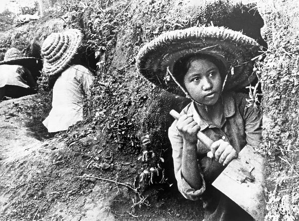 VIETNAM, 1966. Teenage girls digging hillside shelters in Hanoi, North Vietnam