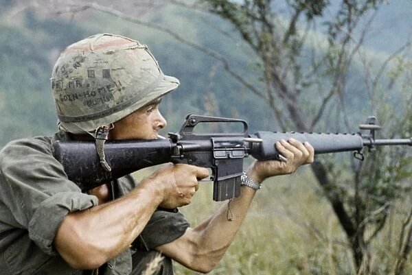 VIETNAM WAR, 1967. Private Michael Mendoza firing a M-16 rifle in the direction of sniper fire