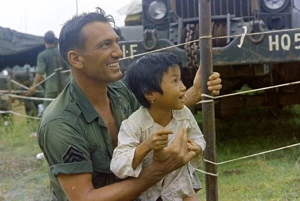 VIETNAM WAR, 1967. Sergeant Hugh Maple playing with a Vietnamese child. Photograph