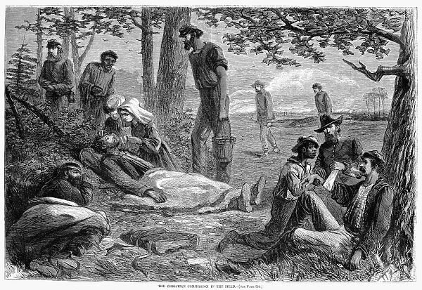 Volunteers of the Christian Commission give first aid to wounded Union soldiers at a battlefield during the American Civil War. Wood engraving from a Northern American newspaper of 1864