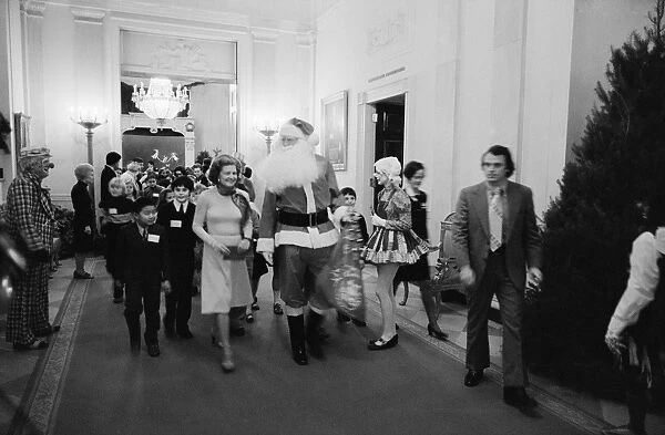 WHITE HOUSE: SANTA CLAUS. First Lady Betty Ford with Santa Claus, and clowns leading
