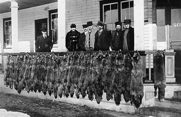 WOLF HUNTERS, c1913. Hunters standing behind a porch rail at Wainwright, Alberta
