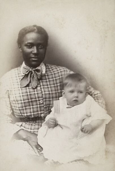 WOMAN AND CHILD, c1875. An African-American woman, probably a nanny, holding a Caucasian baby