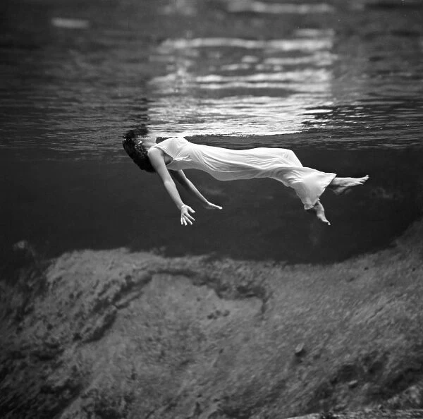 WOMAN FLOATING, 1947. A woman in a fancy dress floating underwater at Weeki Wachee Springs